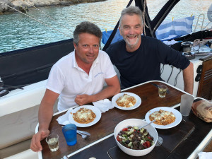 A private sailing yacht anchored in the turquoise lagoons of the Minor Cyclades having lunch with Antonis Biskentzis skipper, showcasing an accessible 2026 off-grid itinerary that avoids the high-traffic crowds and cruise ship taxes of Santorini