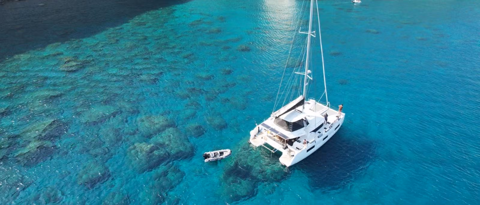 Skippered sailing catamaran anchored in turquoise Aegean waters off Paros with Greek Water Yachts